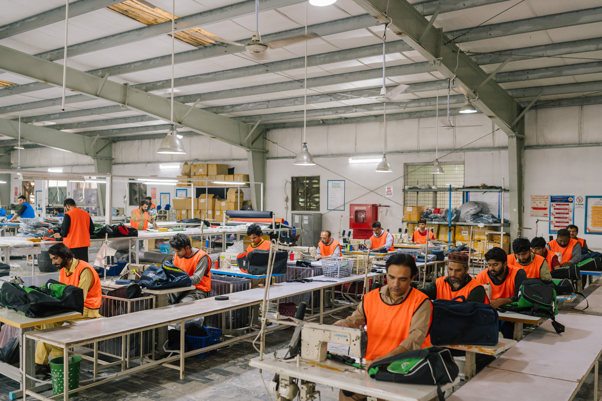 Production floor with stitching lines assembling sports bags and team gear