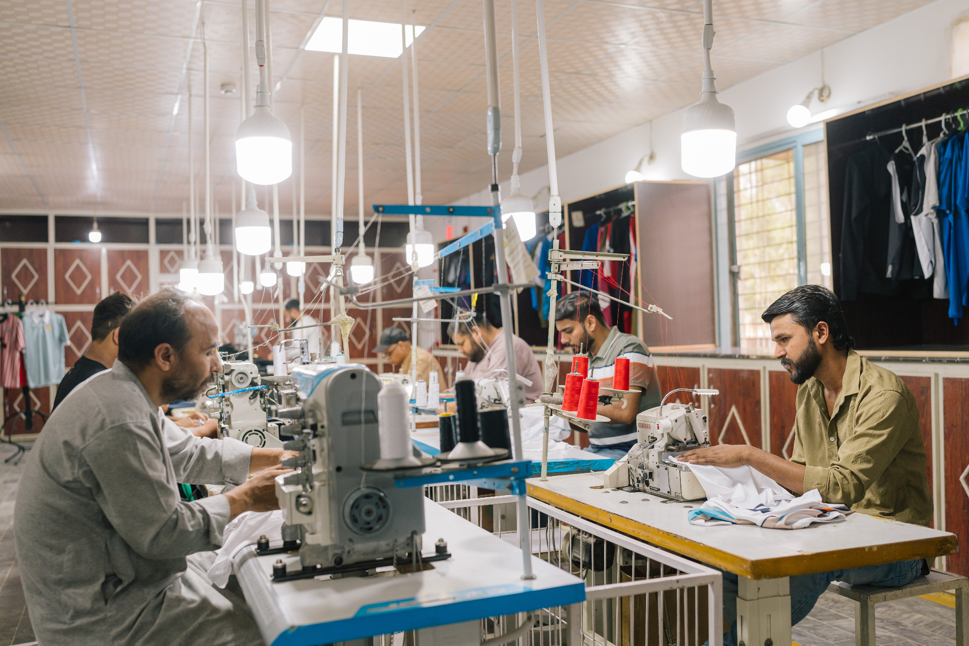 Tailors stitching jerseys at the apparel production line